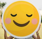 person holding round smiling emoji board photo